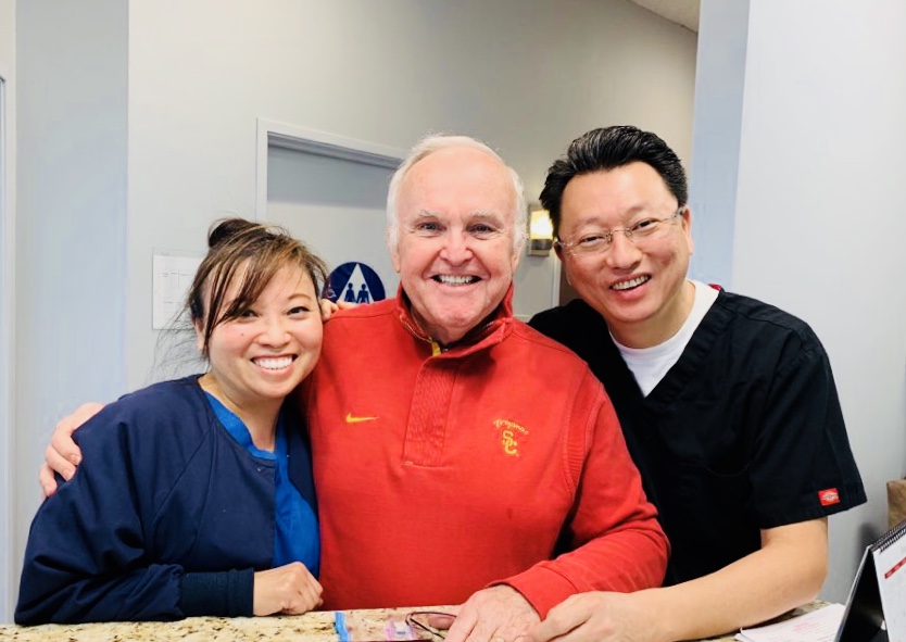 A dental office featuring a computer on a desk and a sink, highlighting a clean and organized workspace.