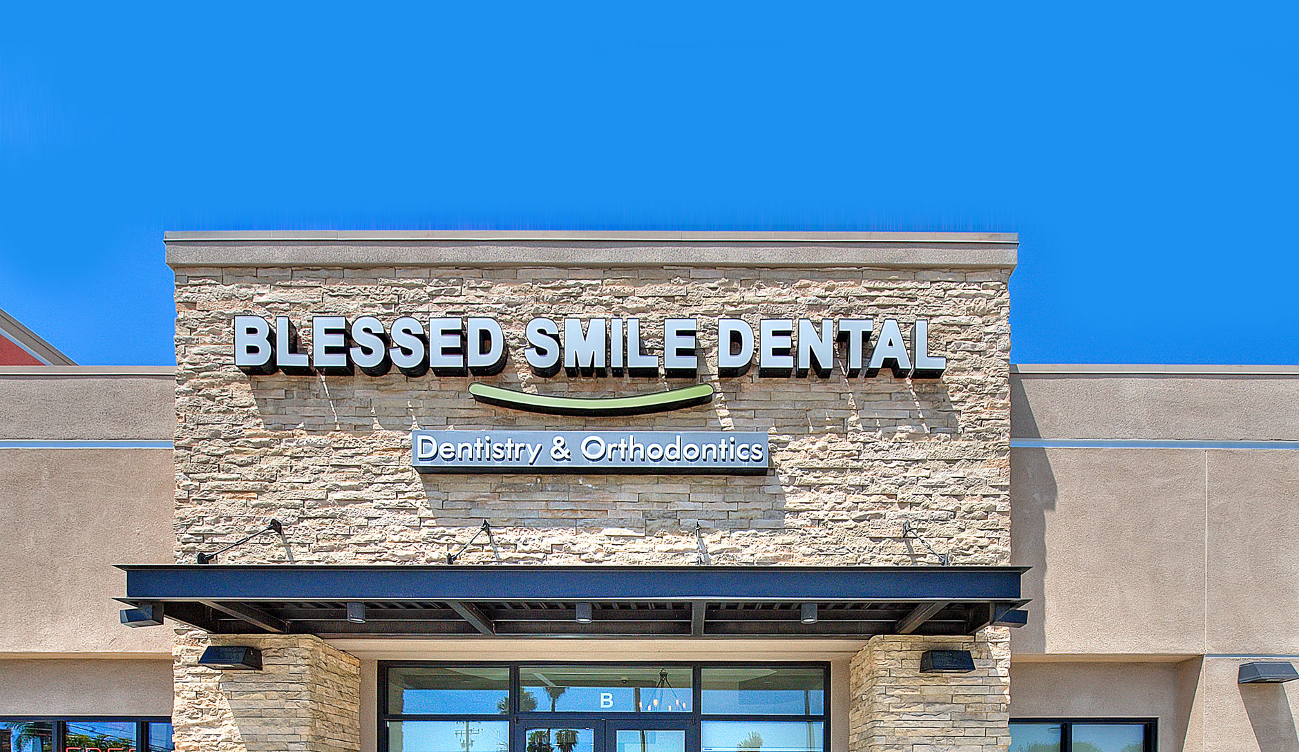 A man in a white coat is seated as a dentist conducts a dental examination.